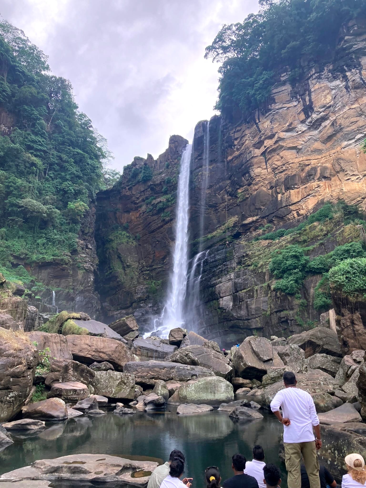 A group of travelers enjoying the view of Laxapana Falls in Sri Lanka