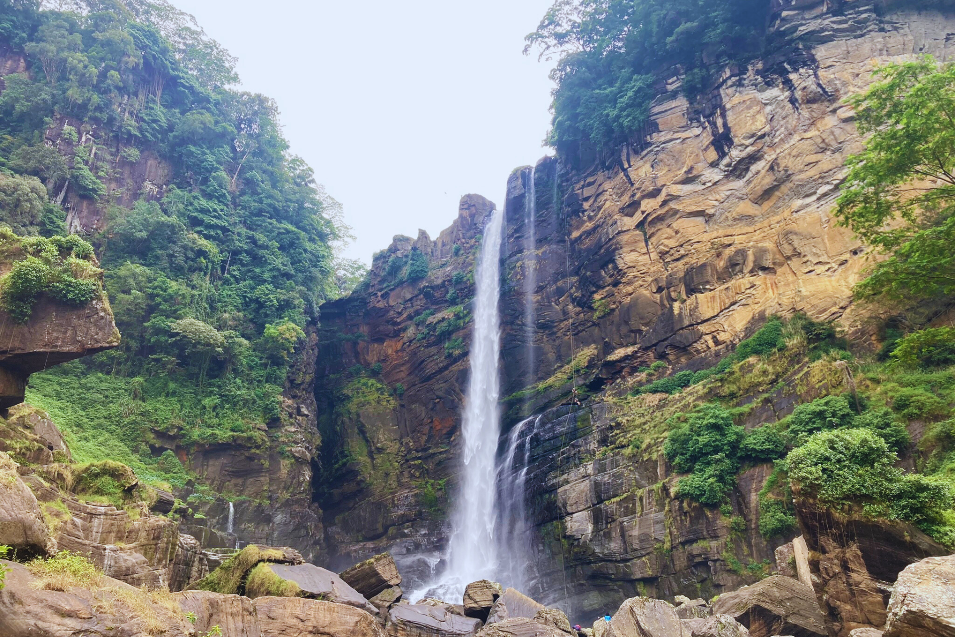 Laxapana Falls in Sri Lanka cascading amidst rocks and greenery.